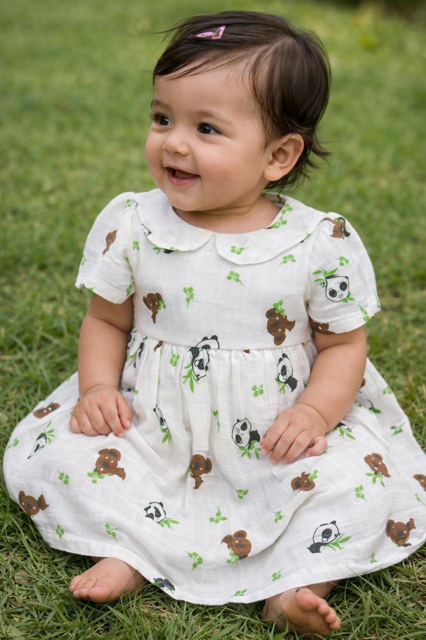 Baby in coral peach puff-sleeve dress lying down, editorial shot