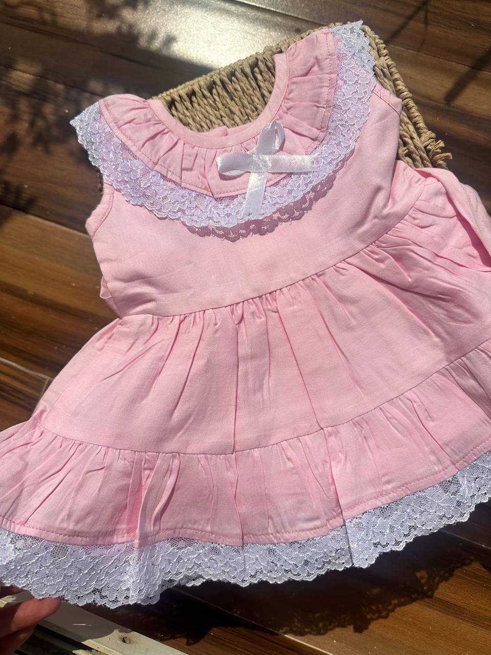 Baby in pink lace ruffle dress sitting